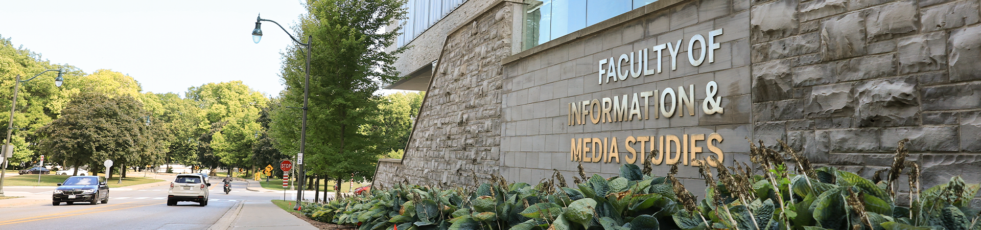 Gold lettering on the outside of the FIMS building reading Faculty of Information and Media Studies
