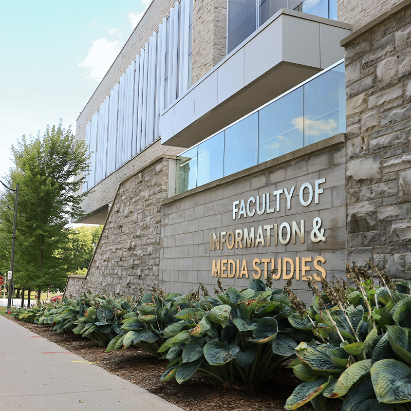 Gold lettering on the outside of the FIMS building reading Faculty of Information and Media Studies