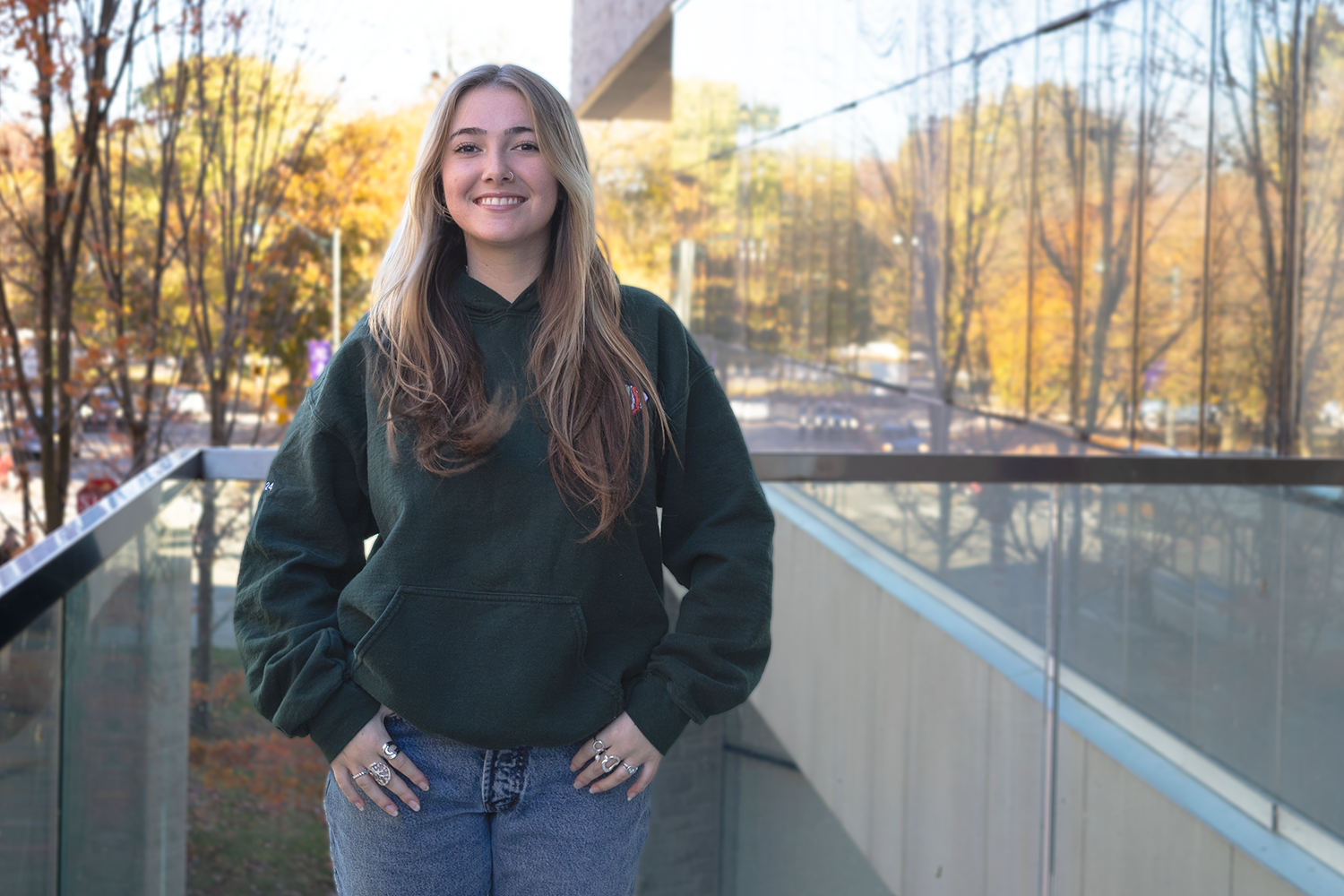 Female student standing outside a building in the fall.